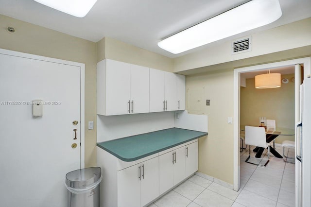 kitchen featuring light tile patterned floors and white cabinetry