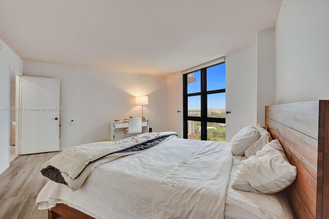 bedroom with light hardwood / wood-style floors and expansive windows