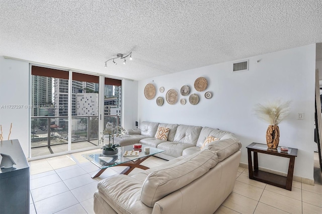 living room featuring floor to ceiling windows, light tile patterned floors, and a healthy amount of sunlight