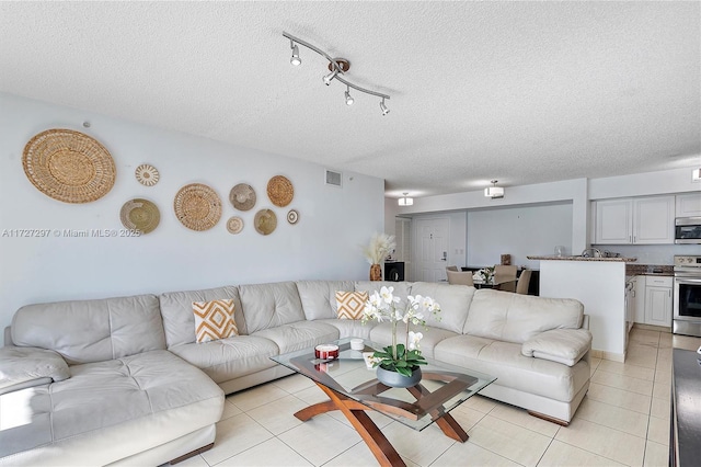 living room with a textured ceiling and light tile patterned floors