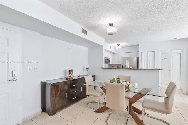 tiled dining room with a textured ceiling