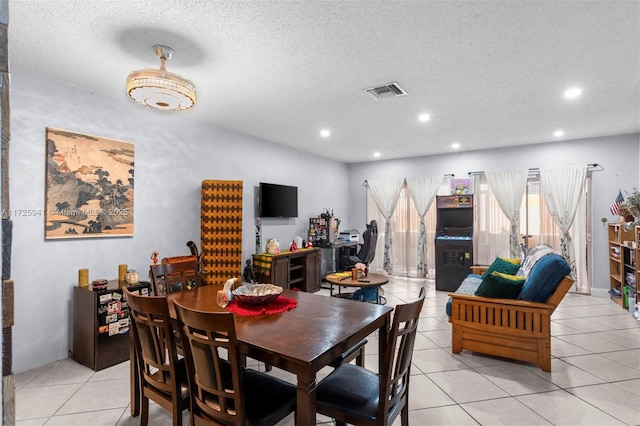 dining area featuring light tile patterned floors and a textured ceiling