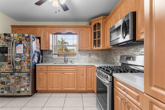 kitchen with ceiling fan, backsplash, sink, light tile patterned flooring, and appliances with stainless steel finishes