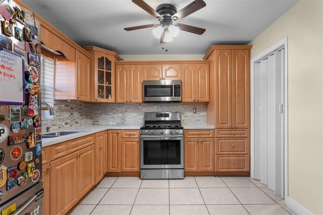 kitchen featuring light tile patterned floors, decorative backsplash, appliances with stainless steel finishes, and sink