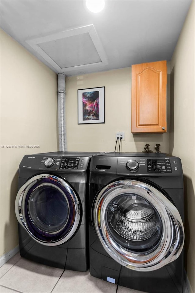 laundry room featuring cabinets, light tile patterned floors, and independent washer and dryer