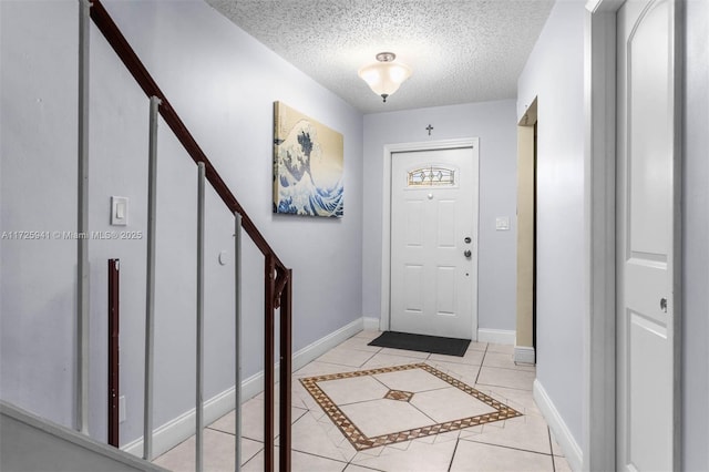 tiled entryway with a textured ceiling