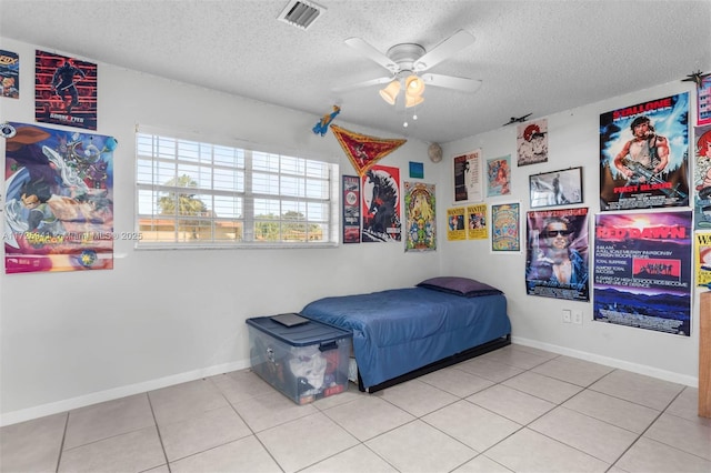 tiled bedroom with ceiling fan and a textured ceiling