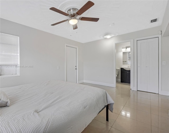 bedroom with ceiling fan, light tile patterned flooring, and connected bathroom