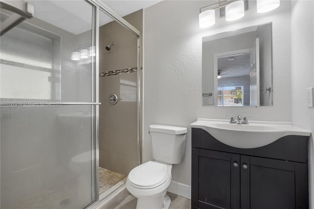 bathroom with toilet, a shower with shower door, and vanity