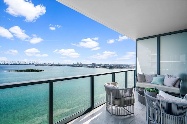 balcony featuring an outdoor living space and a water view