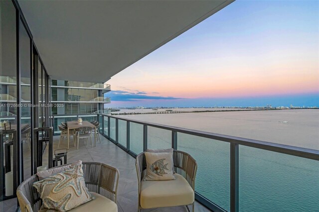 bedroom featuring light parquet flooring, access to outside, and a water view