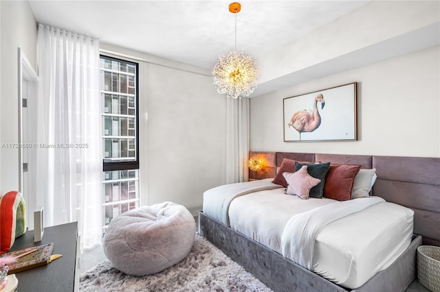 bedroom with an inviting chandelier and multiple windows