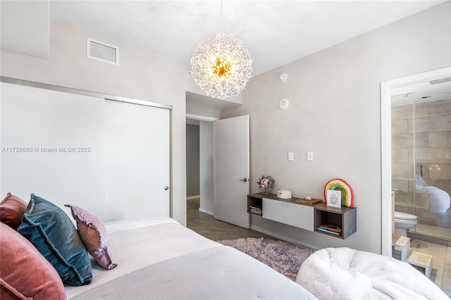 bedroom featuring ensuite bathroom, a closet, and a notable chandelier