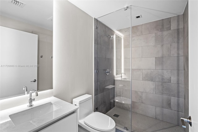 bathroom featuring toilet, an enclosed shower, and vanity