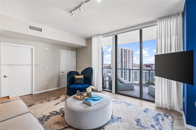 living room with rail lighting and expansive windows