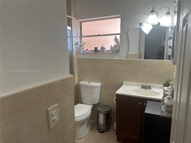 bathroom featuring toilet, tile walls, tile patterned floors, and vanity