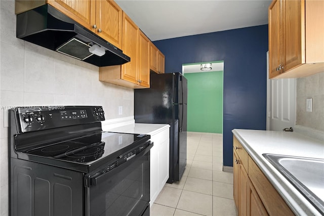 kitchen featuring light tile patterned floors, sink, and black electric range oven