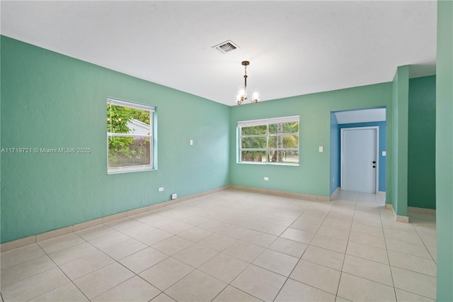 unfurnished room featuring light tile patterned floors and an inviting chandelier