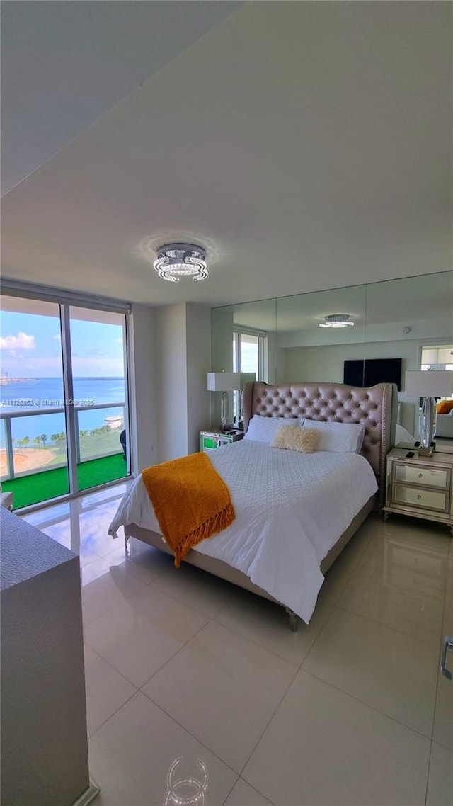 bedroom featuring light tile patterned floors and a water view