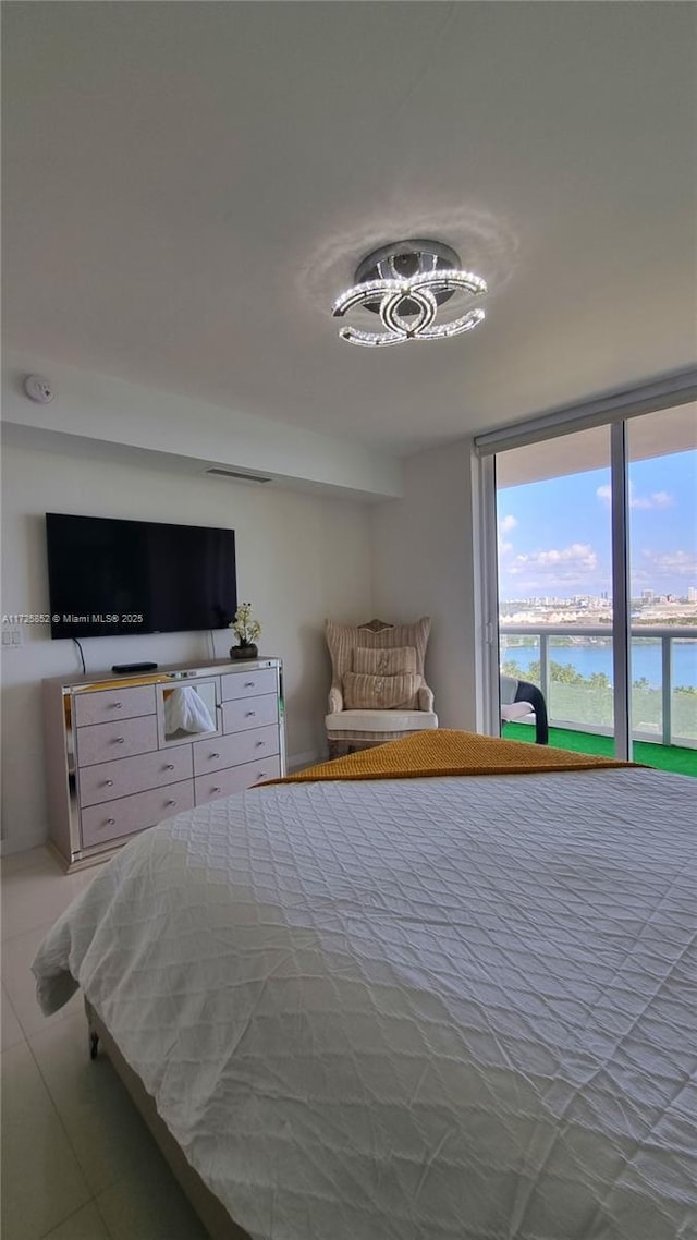 unfurnished bedroom with tile patterned floors and a water view