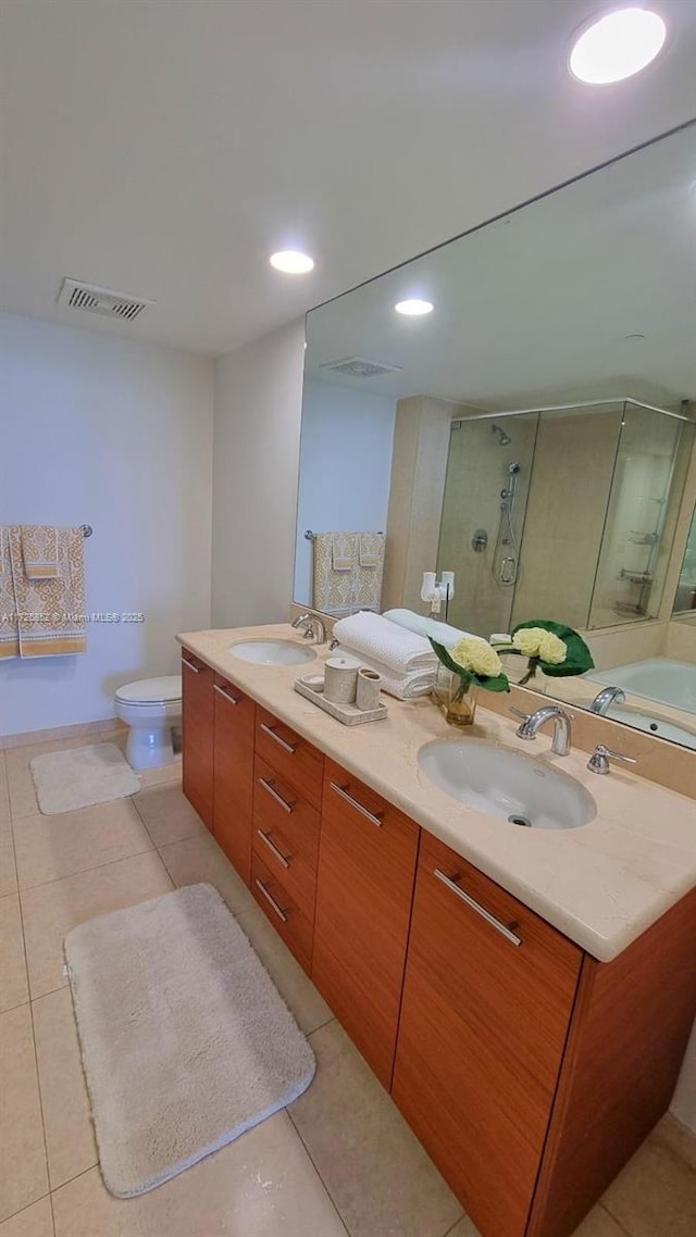 bathroom featuring a shower with shower door, vanity, tile patterned floors, and toilet