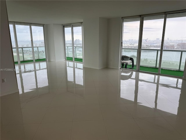 50 Biscayne Blvd Unit 1902, Miami, FL 33132 - tiled spare room featuring expansive windows, a city view, a water view, and baseboards