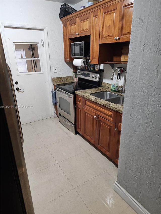 kitchen with sink, stone counters, light tile patterned floors, and electric stove