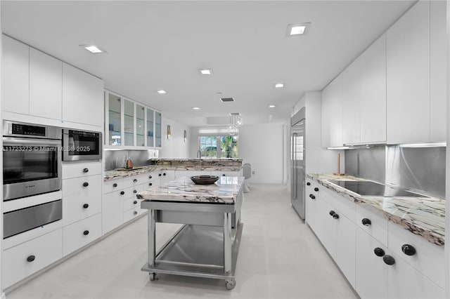 kitchen featuring white cabinetry, stainless steel appliances, a kitchen island, and pendant lighting