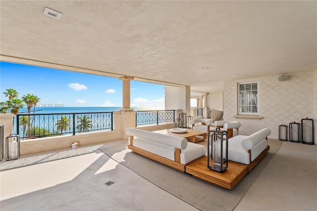 view of patio with a balcony and a water view