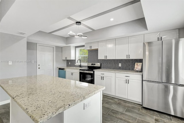 kitchen with pendant lighting, a center island, white cabinetry, stainless steel appliances, and light stone counters