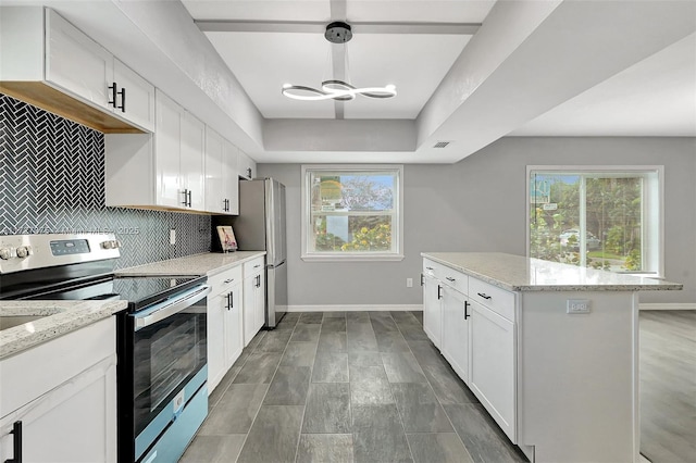 kitchen with appliances with stainless steel finishes, white cabinets, and light stone countertops