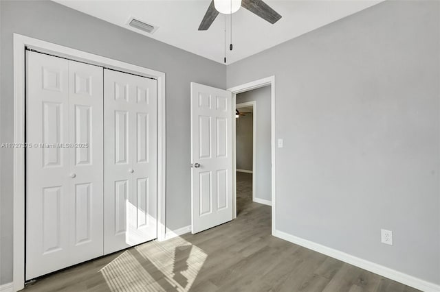 unfurnished bedroom with ceiling fan, a closet, and light wood-type flooring