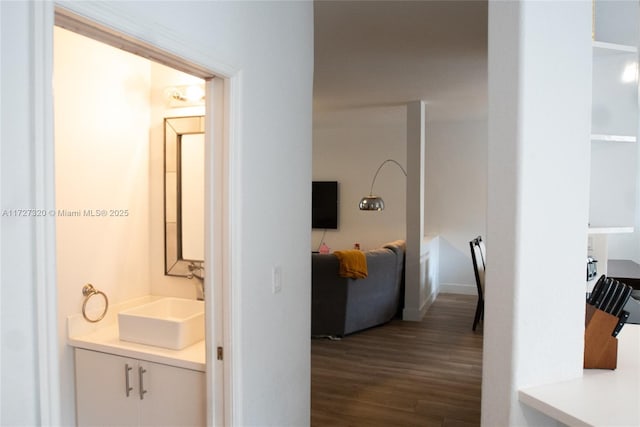 corridor with wood-type flooring and sink