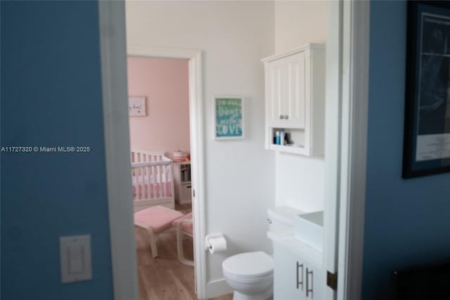 bathroom featuring toilet, vanity, and hardwood / wood-style flooring