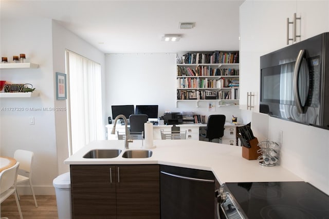 kitchen with stainless steel electric stove, dark brown cabinets, wood-type flooring, dishwasher, and sink