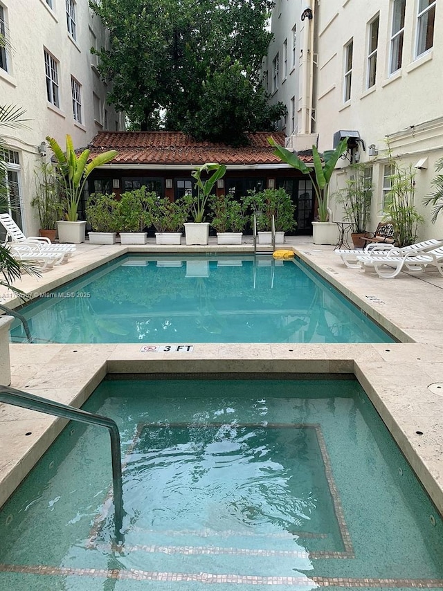 view of pool with a hot tub