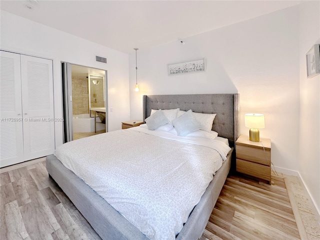 bedroom featuring light hardwood / wood-style flooring and ensuite bath