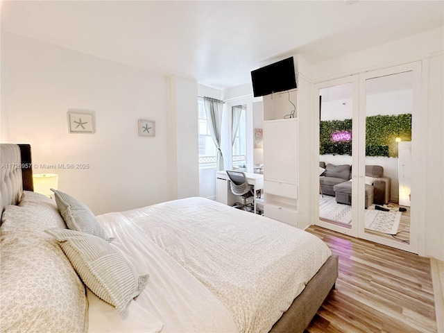 bedroom featuring access to exterior and hardwood / wood-style floors