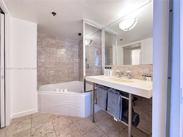 bathroom with backsplash, shower / washtub combination, and sink