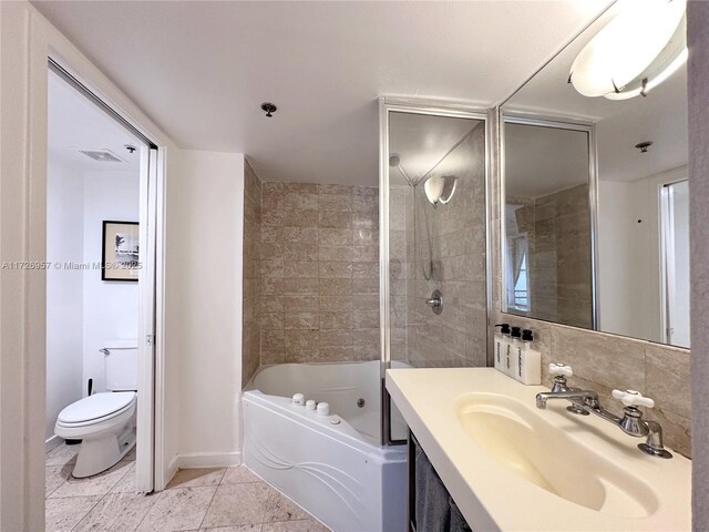 full bathroom featuring toilet, vanity, tiled shower / bath combo, and tile patterned flooring