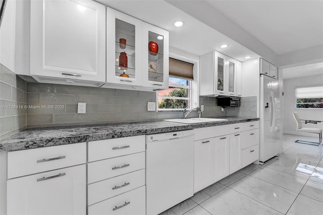 kitchen featuring white cabinets, backsplash, sink, and white appliances