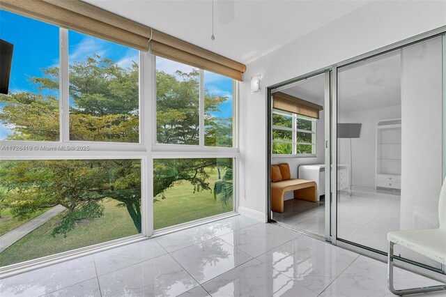 unfurnished sunroom with ceiling fan and a healthy amount of sunlight