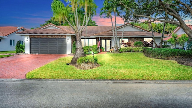 view of front of house with a garage and a yard