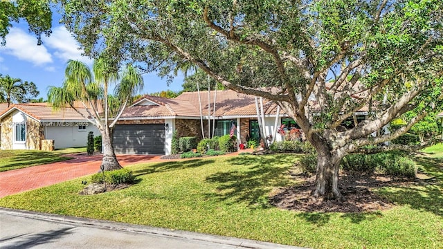 ranch-style home featuring a front lawn and a garage