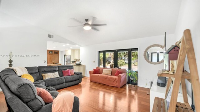 living room featuring ceiling fan, vaulted ceiling, french doors, and light hardwood / wood-style floors