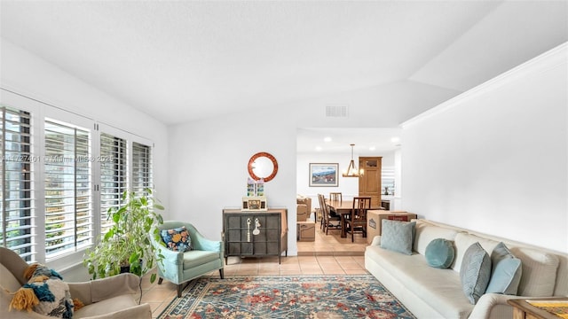 tiled living room with lofted ceiling and an inviting chandelier