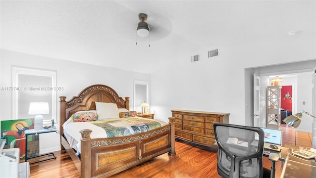 bedroom with ceiling fan, wood-type flooring, and lofted ceiling