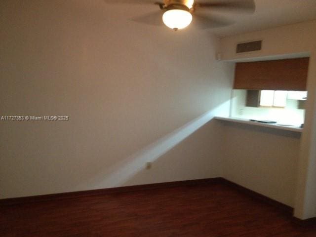 unfurnished room with dark wood-type flooring and ceiling fan