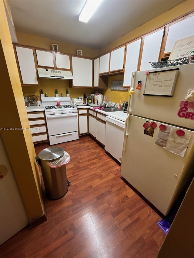 kitchen featuring dark wood-type flooring, white cabinets, and white appliances