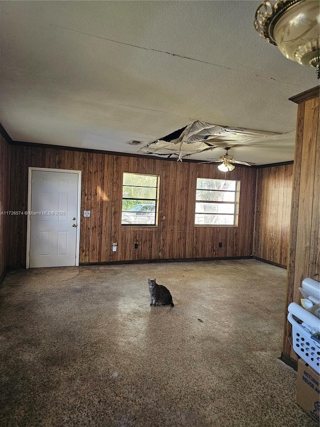 unfurnished room featuring wooden walls and a textured ceiling